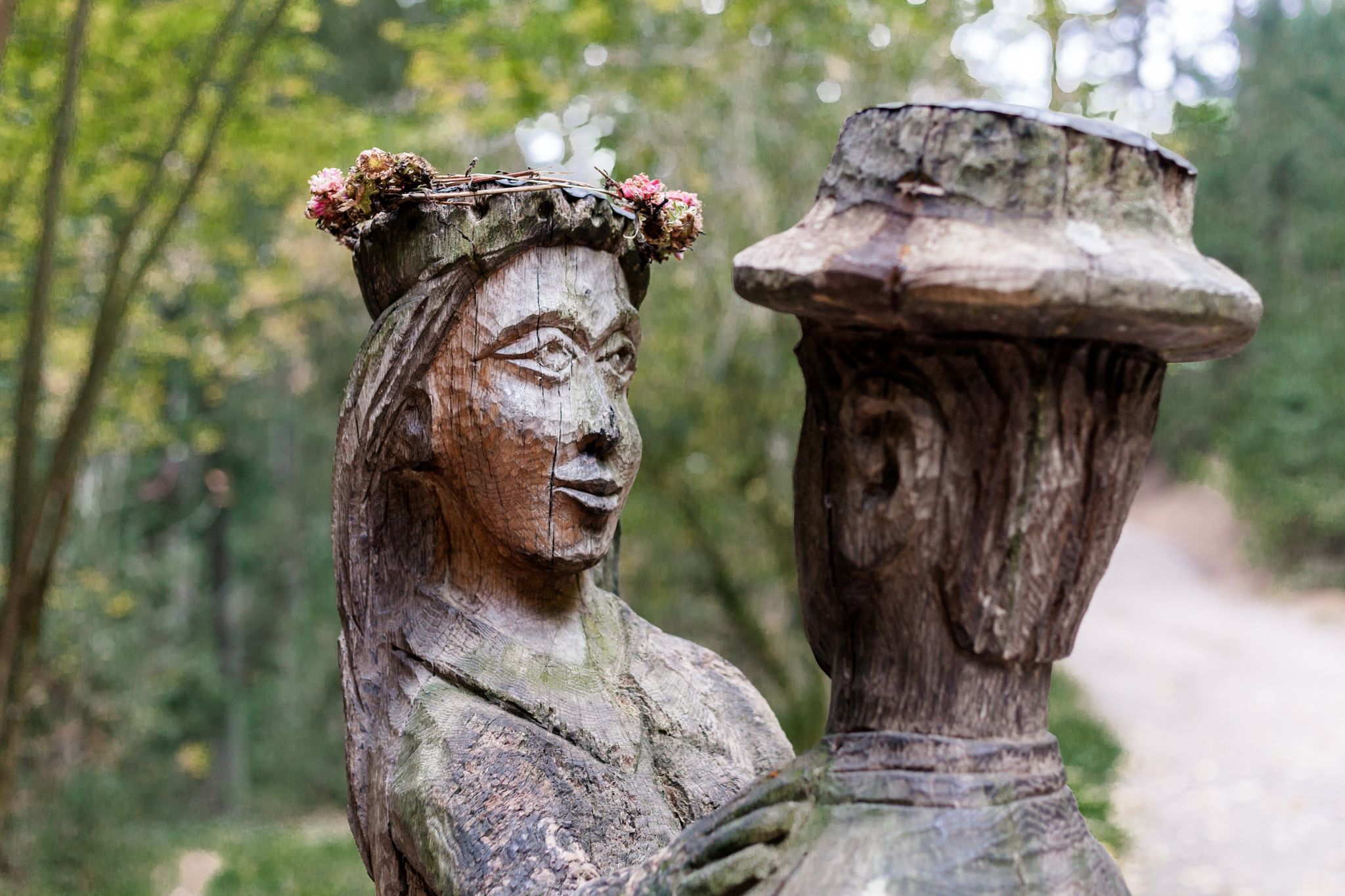 photo of old wooden sculpture in the forest, a man and a woman dancing .Witch hill park, Lithuania.