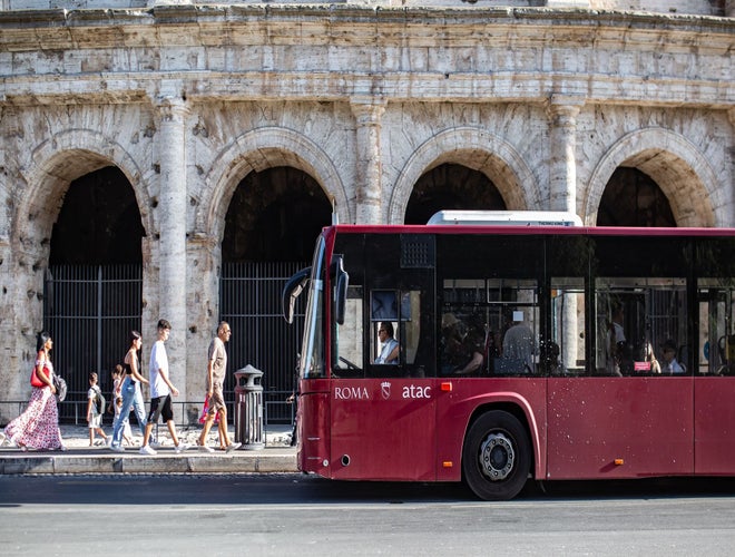 Tourists and public bus near the Colosseum on a sunny afternoon in Italy in June..jpg