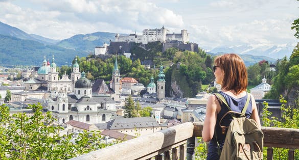 Photo of tourist enjoying the view over the historic district of Salzburg, Austria.