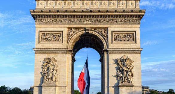 Photo of Arc de Triomphe  Early in the morning with the French flag, France.