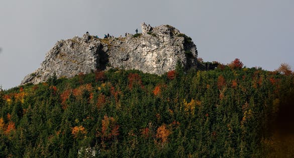 A view of the multicolored autumnal forest and the summit of Sarnia Skała (approximately 1,377 meters above sea level) in the Tatra National Park mountain range from the Dolina Białego trail.