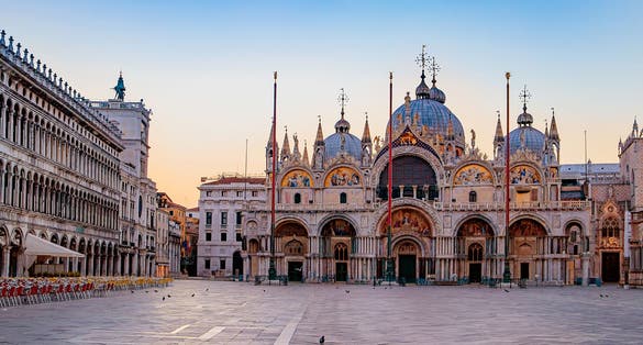 Sunrise in San Marco square with Campanile and San Marco's Basilica. The main square of the old town. Venice, Veneto Italy. Reflection on the flooded square.