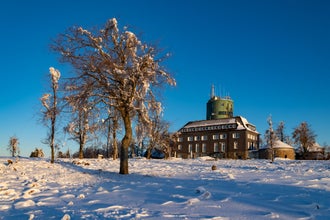Snowy winter wonderland scenery on the “Kahler Asten“ near Winterberg Sauerland. Snow covered public wheather station tower on the highest peak of Northrhine-Westphalia Germany. Warm morning sunlight.