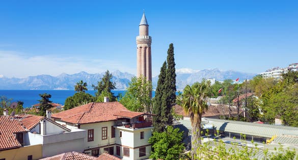 photo of YivliMinare Mosque or Alaaddin Mosque located in Kaleici district old town center of Antalya, Turkey. Sunny weather, clear blue sky and sea.
