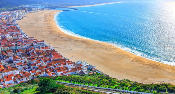 Photo of wonderful romantic afternoon aerial landscape coastline of Nazare beach riviera (Praia da Nazare) with cityscape of Nazare town ,Portugal.