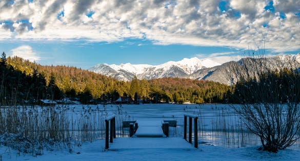 Photo of the frozen Lautersee and the snowy Alps in Mittenwald, Germany.