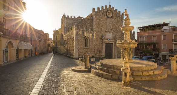 Sunrise at Fontana di Piazza Duomo and Umberto Corso street in Taormina, Sicily island, Italy