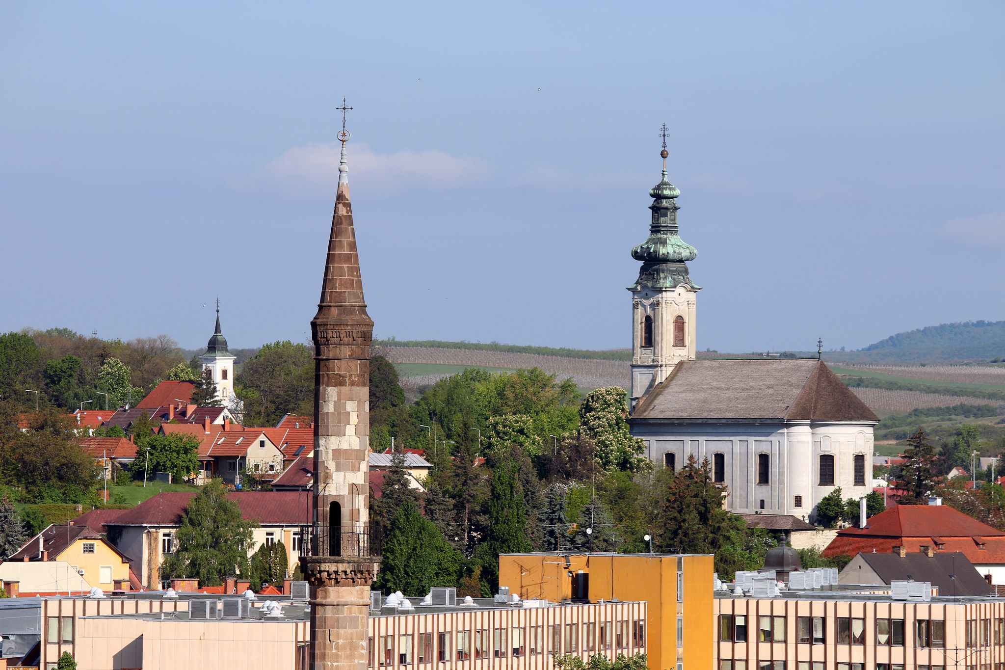 photo of view of minaret and churches different religions in one city Eger Hungary .