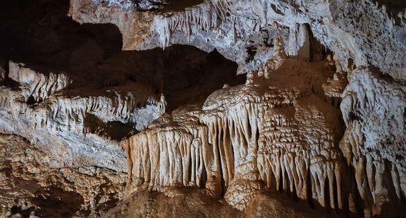 Photo of stalactites and stalagmites in Lipa Cave, formations Columns and Draperies, Montenegro.