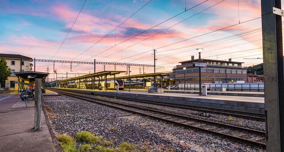 Photo of colorful sky at a Swiss railway station. Mendrisio, example of public transport on rail, Canton Ticino, Switzerland.
