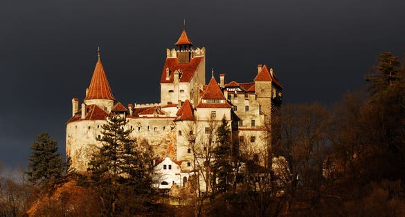 Photo of aerial view of the medieval Castle of Bran at night, known for the myth of Dracula, Romania.