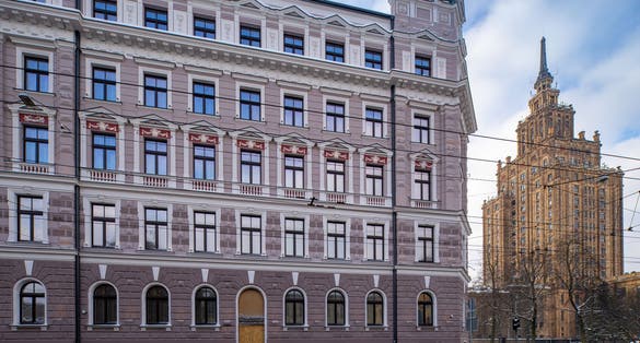 Winter cityscape of Riga. Modern architecture. Snow on road. Cloudy sky. Latvian Academy of Sciences