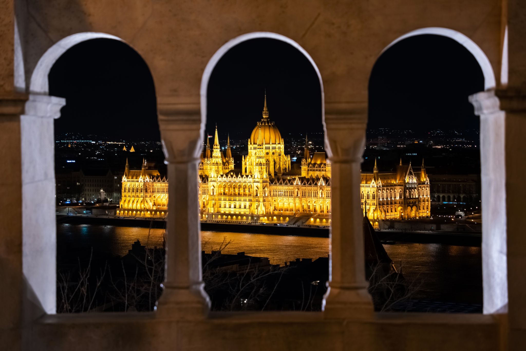 Photo of night time view of the illuminated Hungarian Parliament Building from the Fisherman's Bastion in Budapest, Hungary.