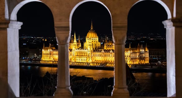 Photo of night time view of the illuminated Hungarian Parliament Building from the Fisherman's Bastion in Budapest, Hungary.