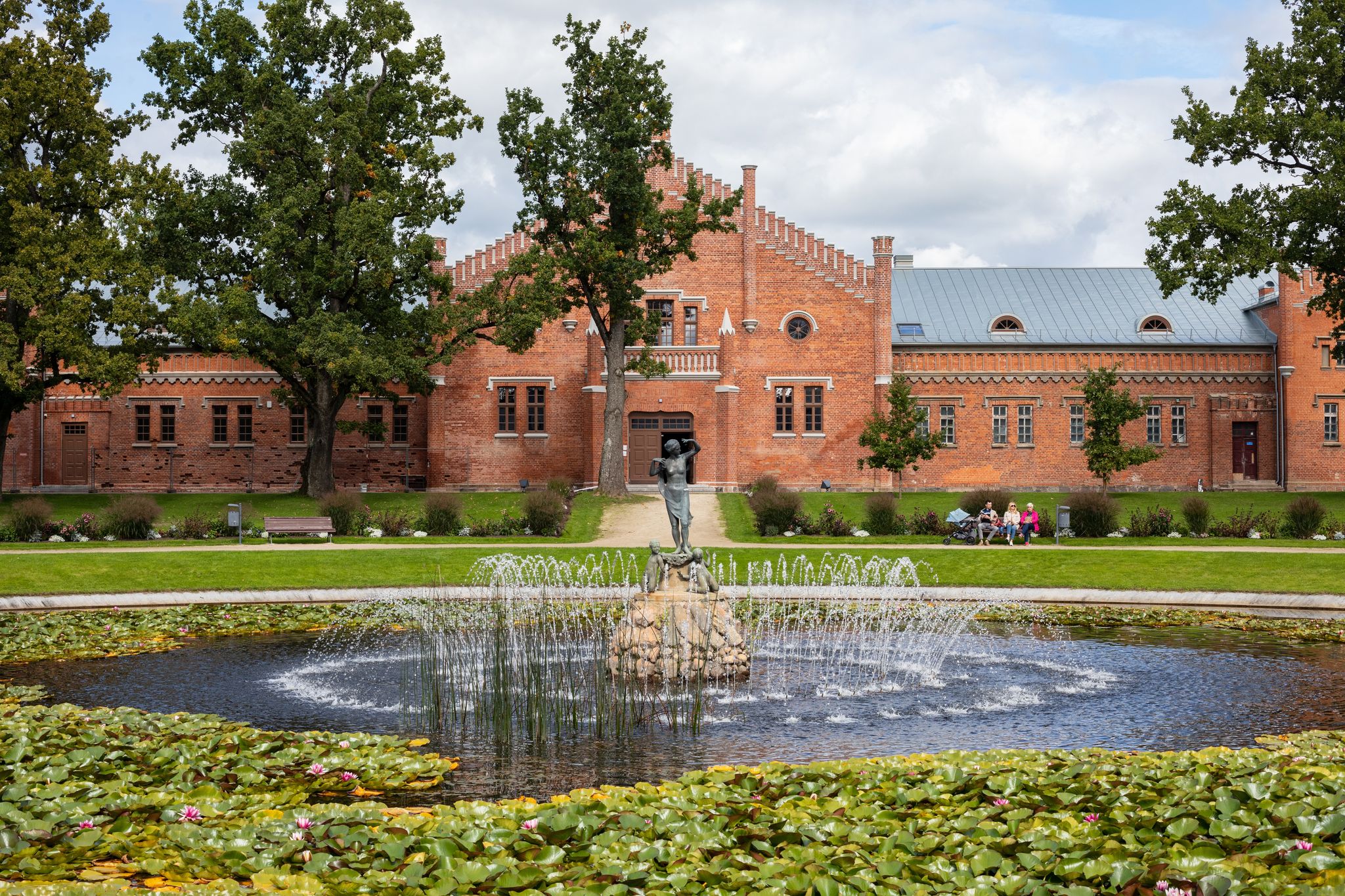 photo of Plunge, Lithuania - September 5, 2021: View to the fountain and mews of plunge manor or oginski residential manor (1879).