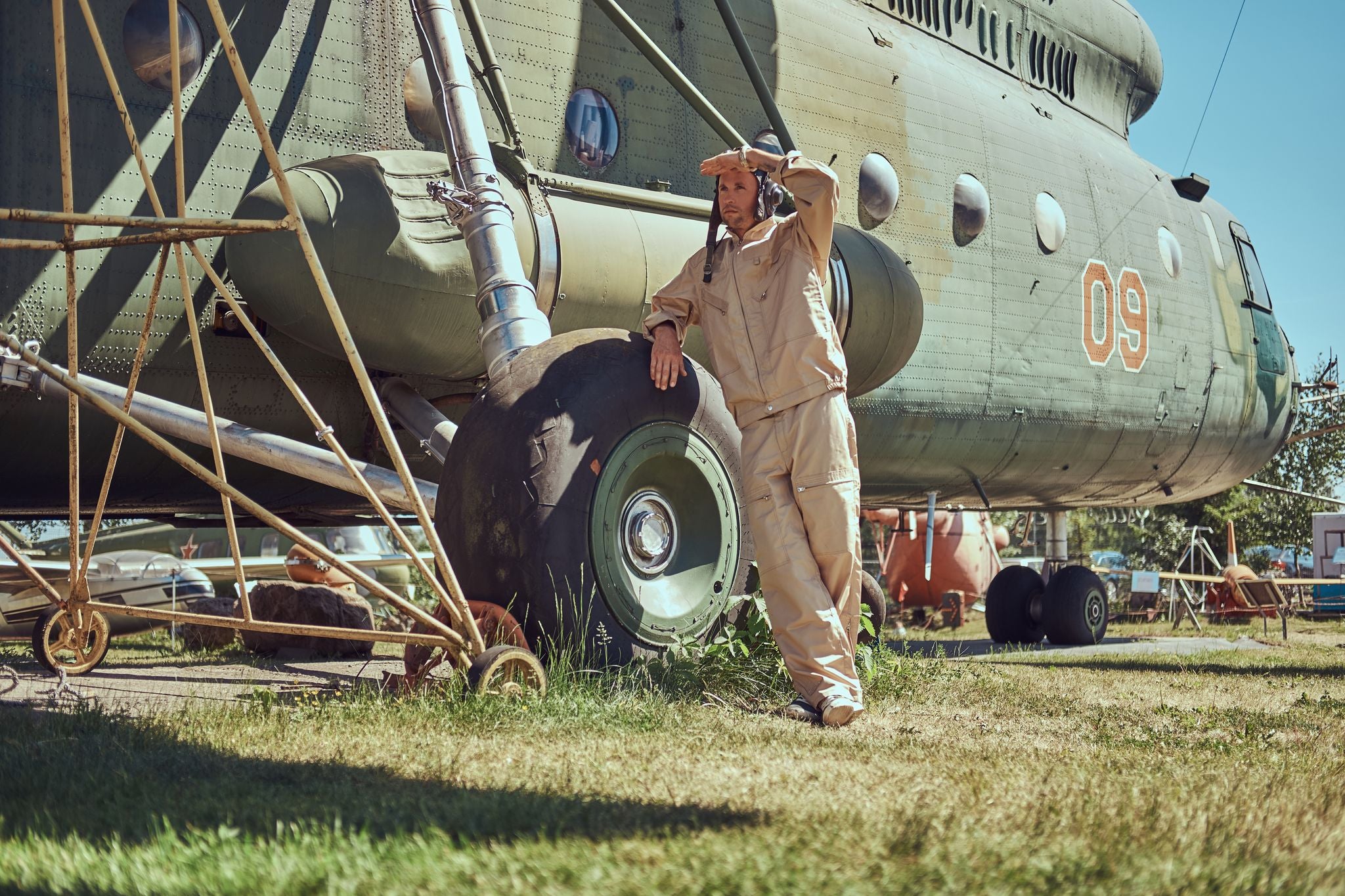 Photo of Mechanic in uniform and flying near the large military helicopter in Aviation Museum in Belarus.