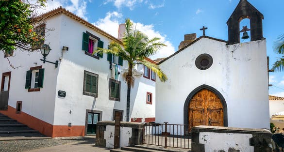 Photo of picturesque chapel (capela do Porto Santo) in a street of the old town of Funchal, Madeira island, Portugal.
