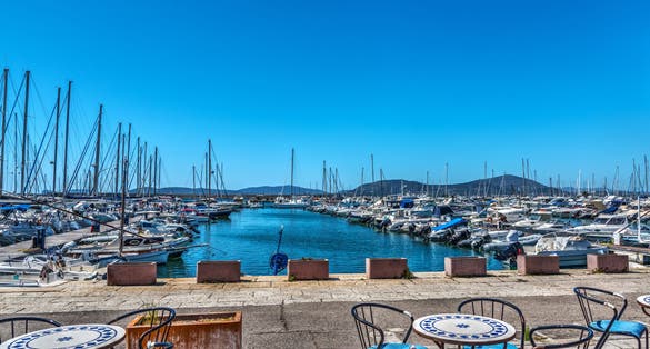Tables and chairs by Alghero harbor. Sardinia, Italy