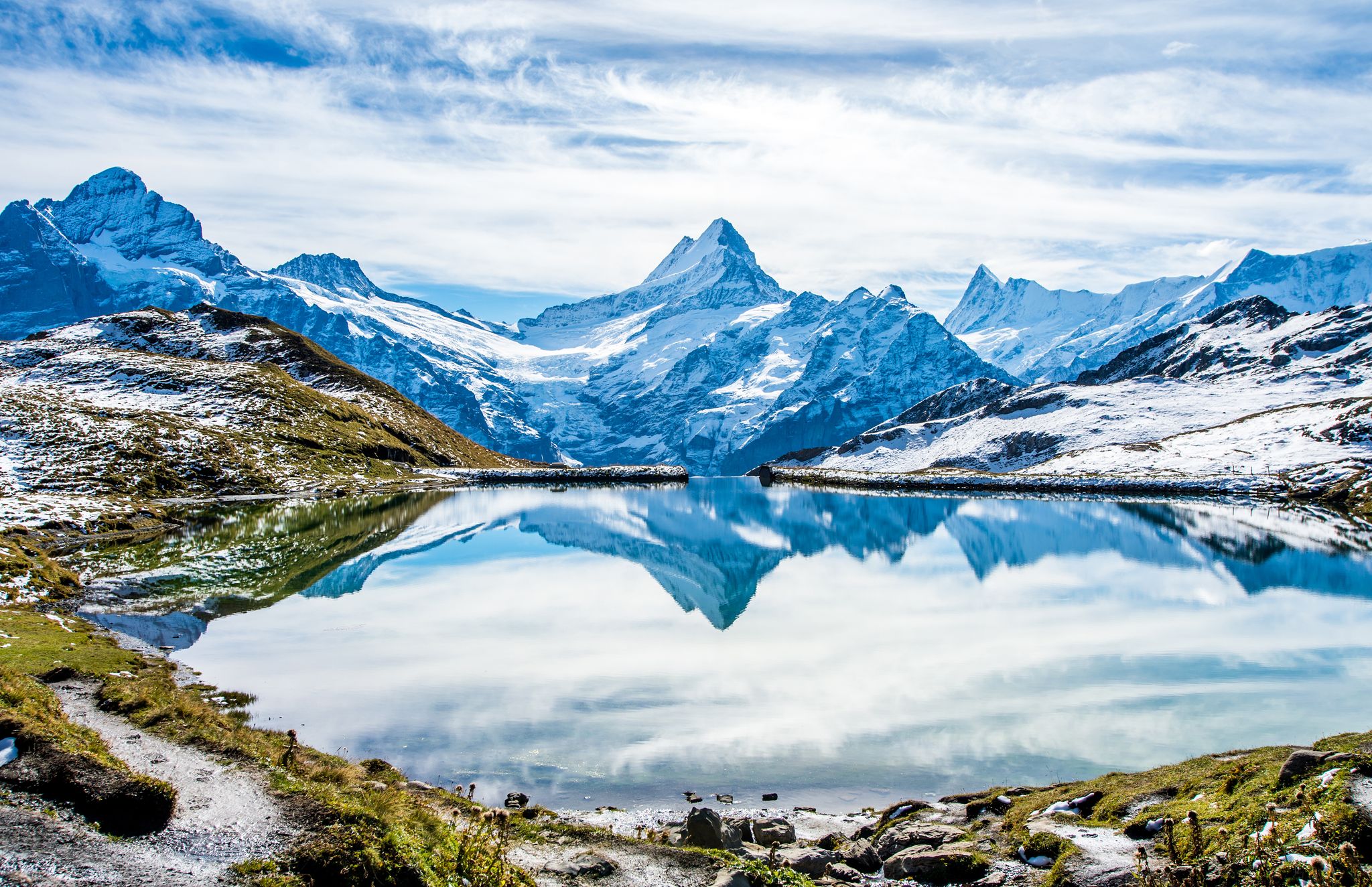 Photo of Swiss alps water reflection in Bachalpsee - mountain lake above Grindelwald, Switzerland.