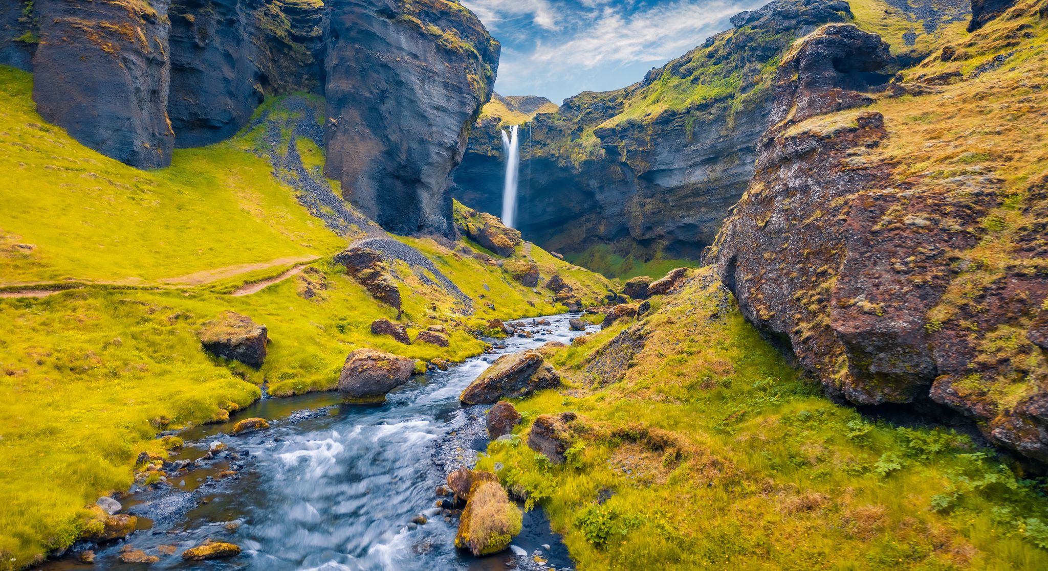 photo of View from flying drone. Yellow grass on the hills on Kvernufoss watterfall. Majestic summer view of pure water river in Iceland.
