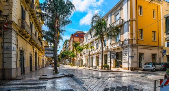 Empty streets and closed shops and cafes on a summer morning on the main street, Corso Umberto, through the town center of the coastal city of Brindisi, Italy.