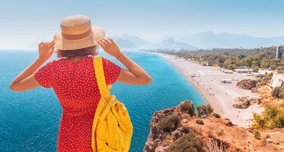 Photo of tourist looking from the height of the observation viewpoint overlooking Konyaalti beach in Antalya, Turkey.
