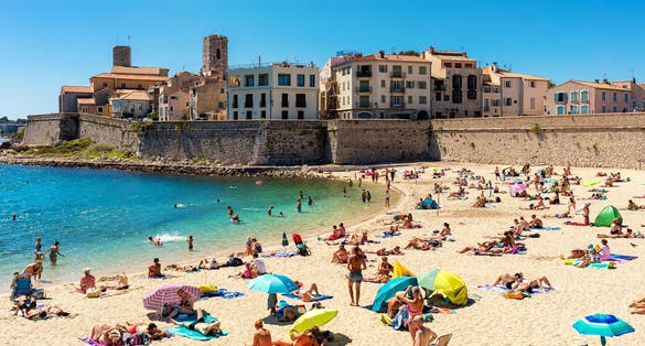 People on Plage de la Gravette - famous and popular sand beach near the Old Town of Antibes, France.