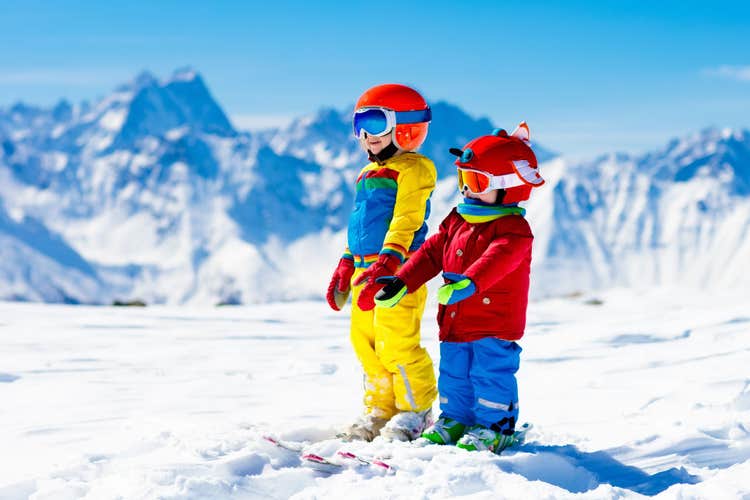 Photo of family Christmas vacation in the Alps. Children learn downhill skiing, Les Deux Alpes.