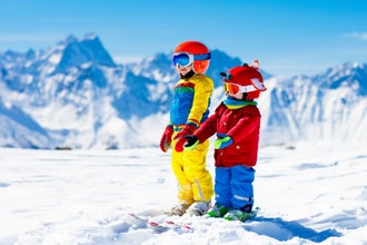 Photo of family Christmas vacation in the Alps. Children learn downhill skiing, Les Deux Alpes.