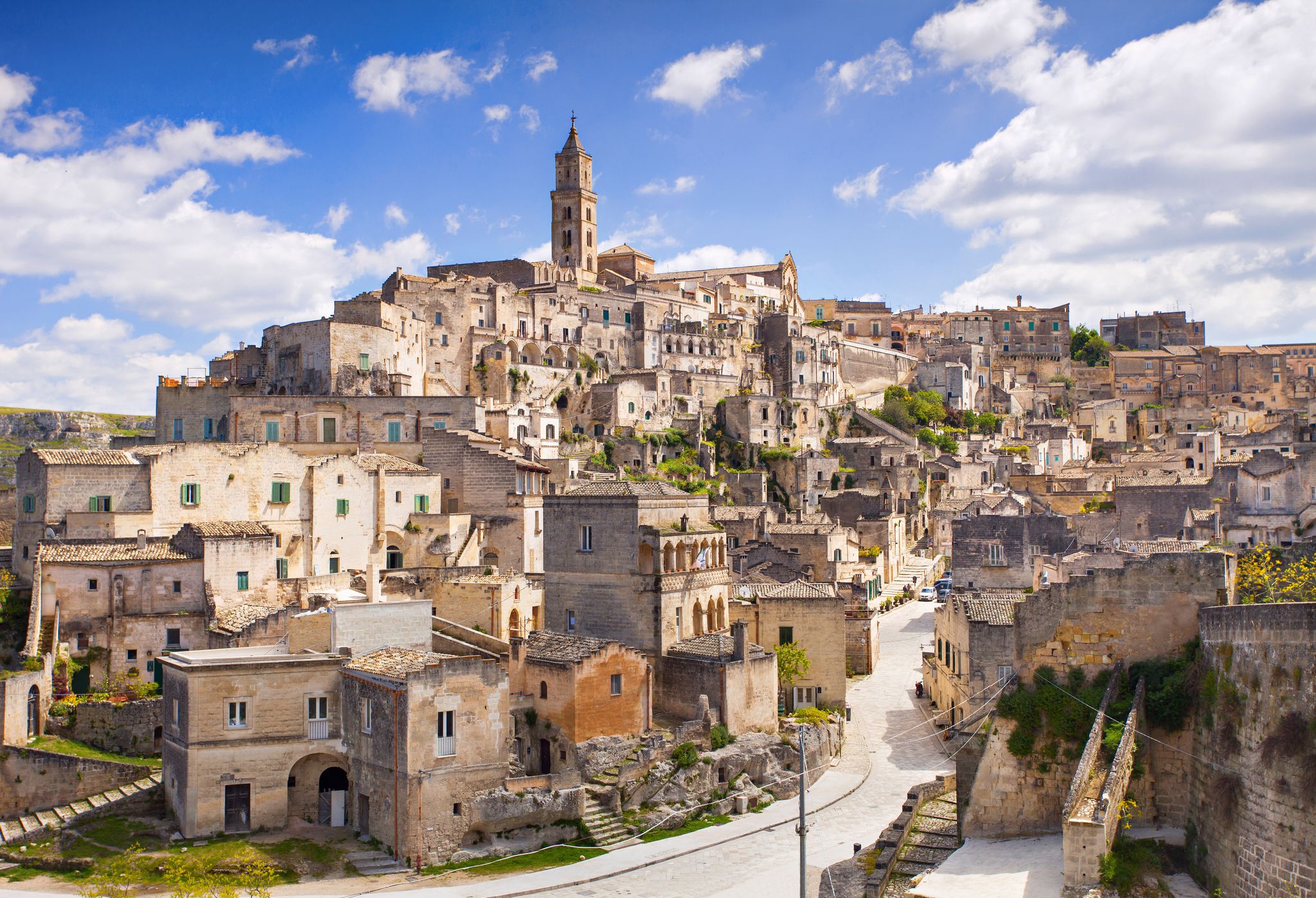 Photo of panoramic view of the ancient town of Matera (Sassi di Matera), European Capital of Culture 2019, in beautiful golden morning light with blue sky and clouds, Basilicata, southern Italy.