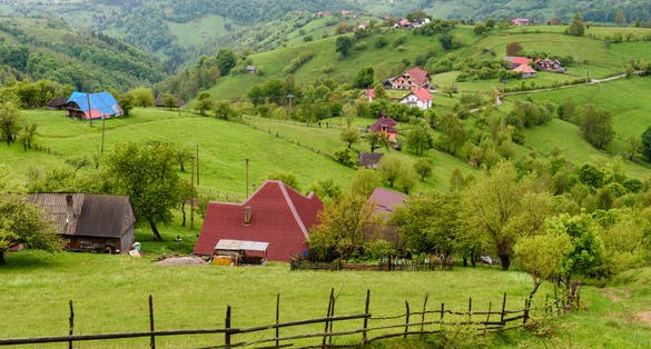 Photo of Magura, Transylvania, Romania. Landscape with houses on green hills. Rural countryside in romanian mountains near Zarnesti, Bran and Brasov in Piatra Craiului National Park, Romania .