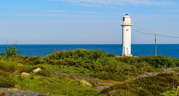 photo of The Subbe lighthouse in southern Varberg, Sweden, with surrounding landscape on a sunny and calm morning.