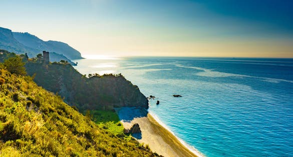 Photo of coast view with watchtower. Torre Del Pino, Pine tower on cliffs of Maro Cerro Gordo Natural Park, Malaga province.