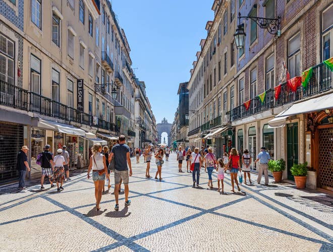 Tourists strolling along Rua Augusta in Lisbon’s Baixa district, enjoying sunny weather in Portugal in August..jpg