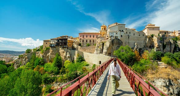 photo of a female tourist at San Pablo Bridge enjoying the beautiful view in Cuenca, Spain.