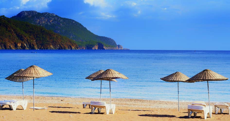 Photo of beautiful beach umbrellas on the shore of the cozy bay of Adrasan, near Antalya and Kemer.