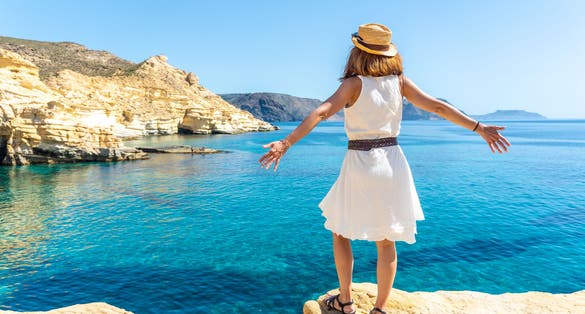 Photo of tourist woman looking at the sea in Rodalquilar in Cabo de Gata on a beautiful summer day, Almería.