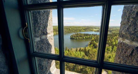 Photo of landscape view through a window at the lookout tower of Aulanko nature park in Finland.