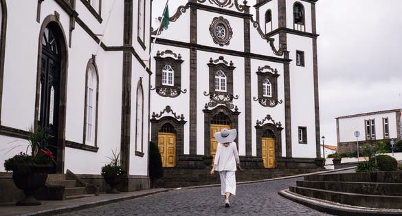 Photo of woman traveling in Azores island walking in city with white buildings, Ponta Delgada ,Portugal.