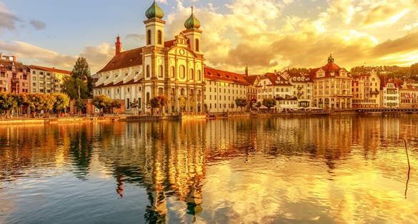 photo of amazing colorful sunset Jesuit Church of St. Francis Xavier reflects on Reuss river in Lucerne , Switzerland.