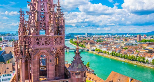 Photo of riverside of Rhine in Basel dominated by majestic building of Munster church, Switzerland.