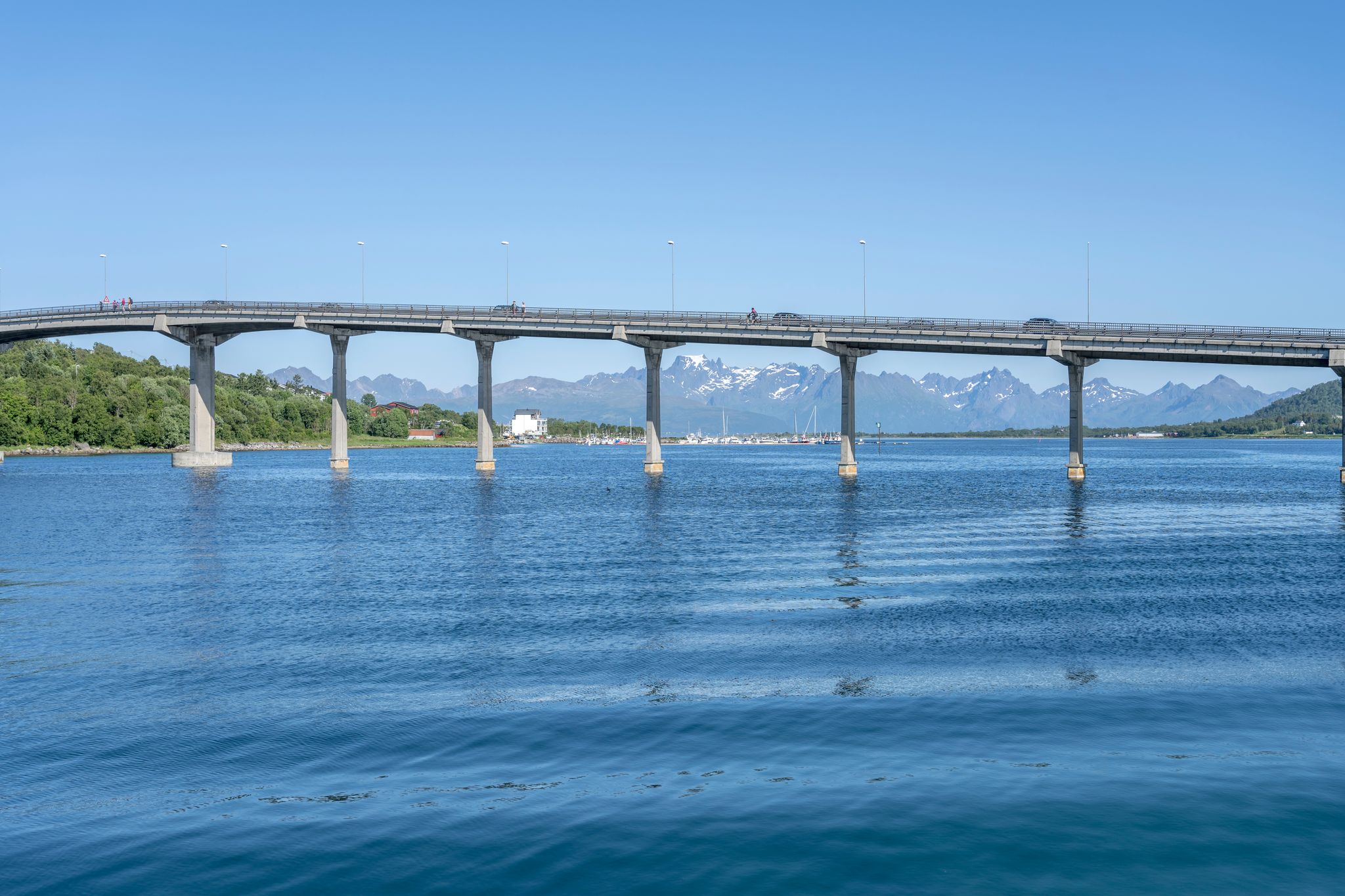 photo of view of concrete bridge with harbor in background, shot under bright summer light at Stokmarknes, Hadseloya, Vesteralen, Norway