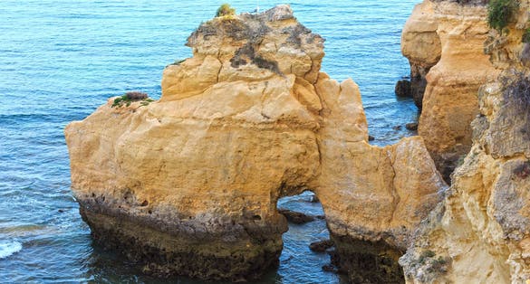 Photo of summer Atlantic ocean coast view with rock formations (Porches, Lagoa, Algarve, Portugal).
