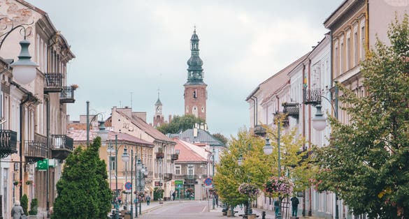 Photo of Pedestrian street in the city center with Church tower of St. Jacob in the background in Radom, Poland.