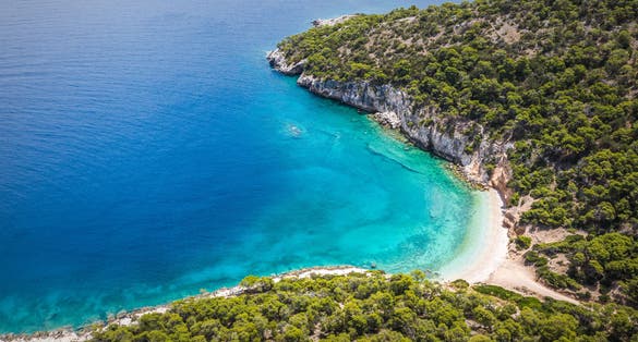 Photo of aerial view of seals cave and beautiful beach in Loutraki, Greece.