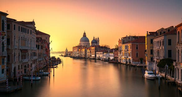 photo of Beautiful view of traditional Gondola on Canal Grande with Basilica di Santa Maria della Salute in the background on a sunny day in Venice, Italy .