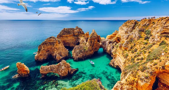 Photo of panoramic beautiful view of Ponta da Piedade with seagulls flying over rocks near Lagos in Algarve, Portugal.