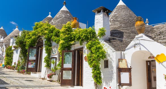 Beautiful town of Alberobello with trulli houses among green plants and flowers, main touristic district, Apulia region, Southern Italy.