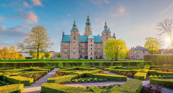Photo of Rosenborg Castle Gardens in Copenhagen, Denmark with blue sky.