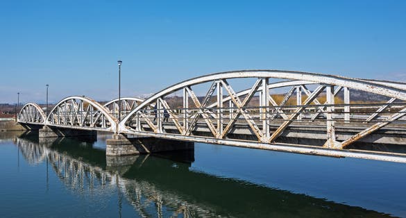 Steel bridge over the water, over Jiu. Ferdinand Bridge in Targu Jiu.